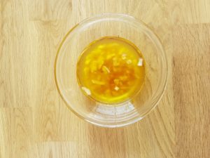 Une sauce vinaigrette au vinaigre de cidre, au citron, à l'huile d'olive, à l'huile de noisette et à l'échalote dans une coupelle en verre transparent