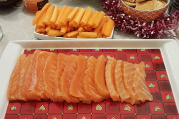 Tranches de saumon gravlax disposées dans un plat avec des accompagnements