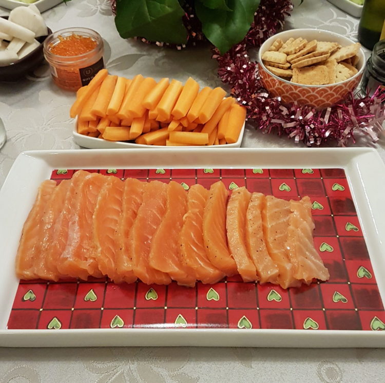 Tranches de saumon gravlax disposées dans un plat avec des accompagnements