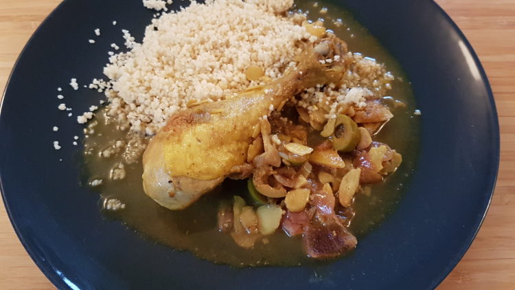 Assiette avec pilon de poulet et une sauce au citron et olives vertes accompagné de semoule